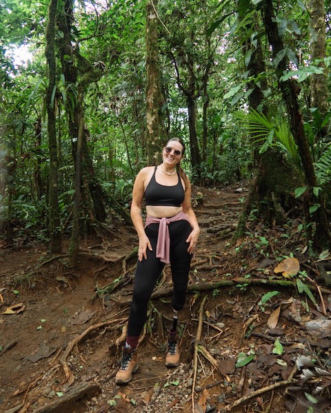 Mulher numa caminhada na selva a sorrir