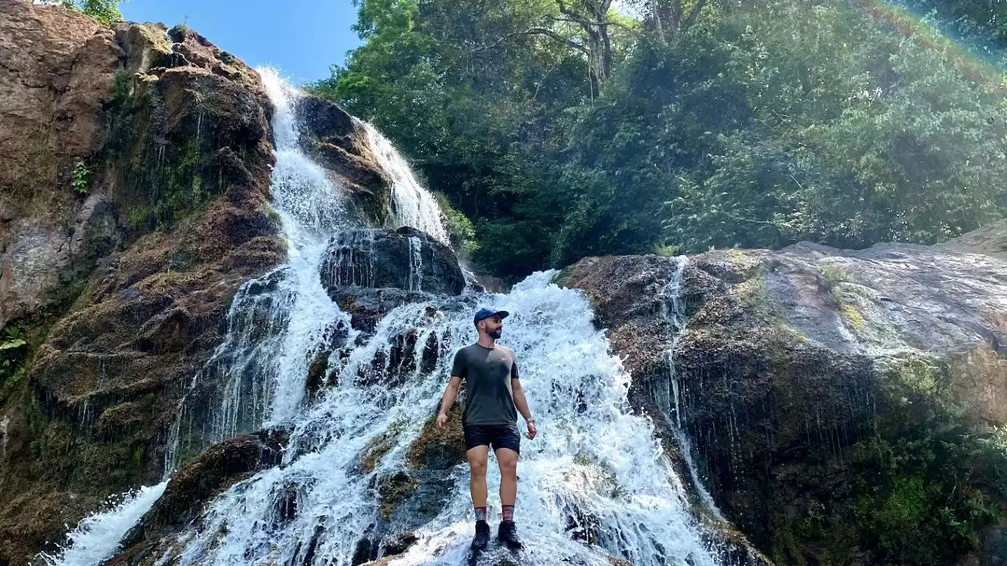 Um homem em frente a uma cascata