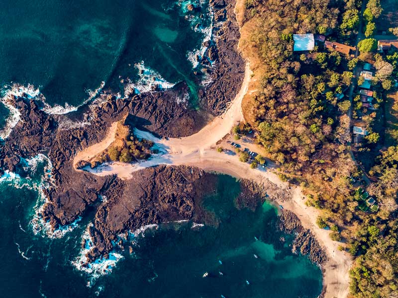 Uma vista aérea de uma praia de areia e do oceano.