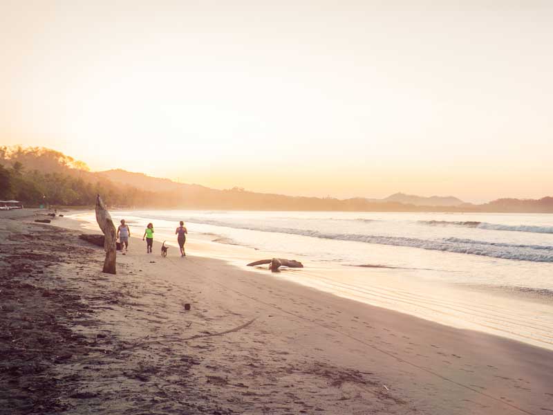 Um grupo de pessoas em cima de uma praia de areia.