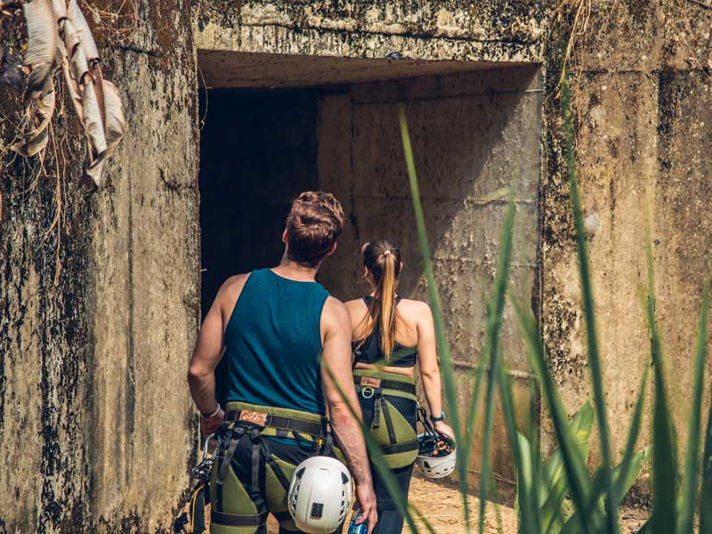 Um homem e uma mulher a sair de uma gruta.