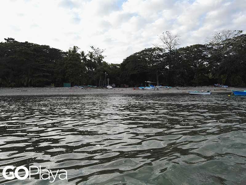 Uma massa de água com barcos em fundo.
