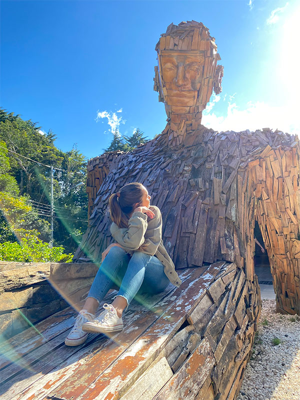 Uma mulher sentada em cima de um banco de madeira.