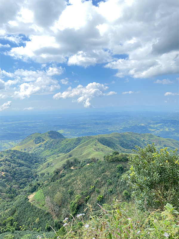 Uma vista panorâmica de uma cadeia de montanhas com nuvens no céu.