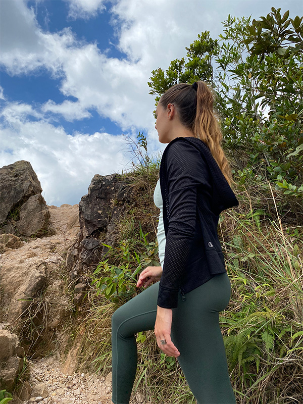 Uma mulher com um top preto e leggings verdes