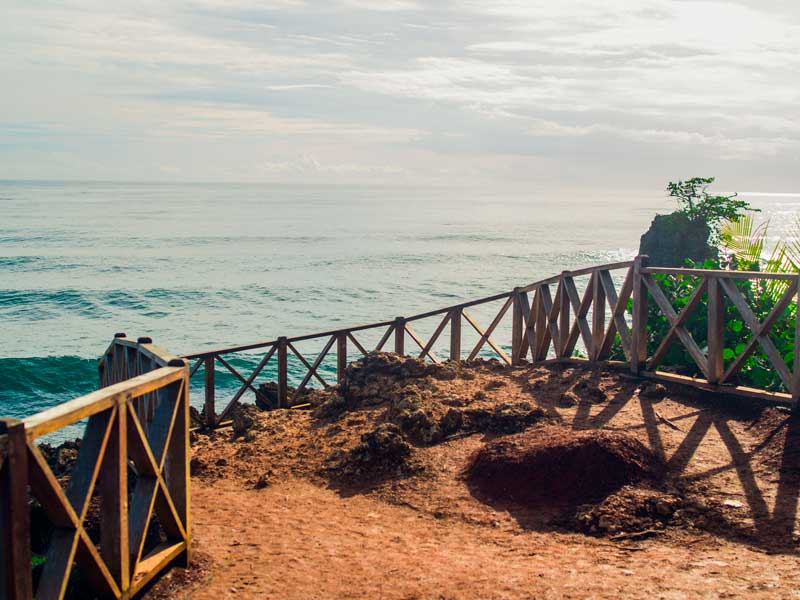 Um passadiço de madeira que conduz ao oceano num dia nublado.