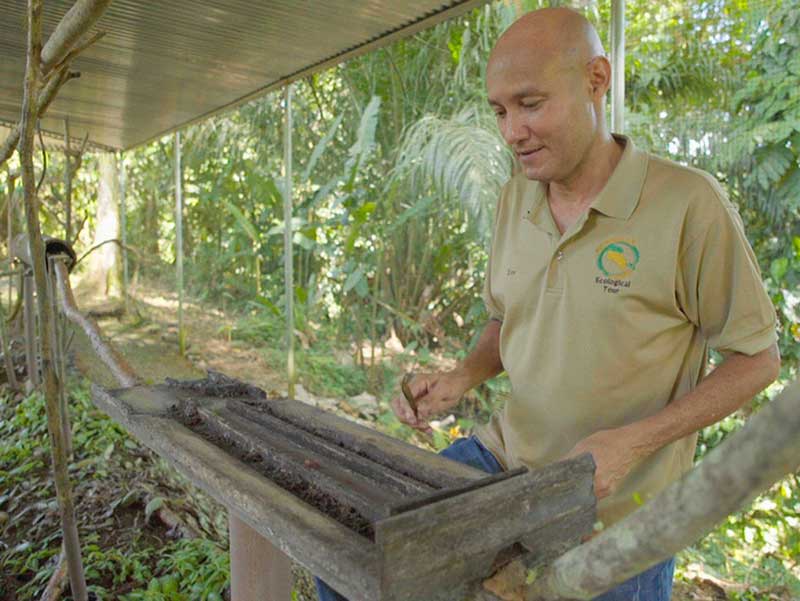 Um homem junto a uma caixa de madeira.