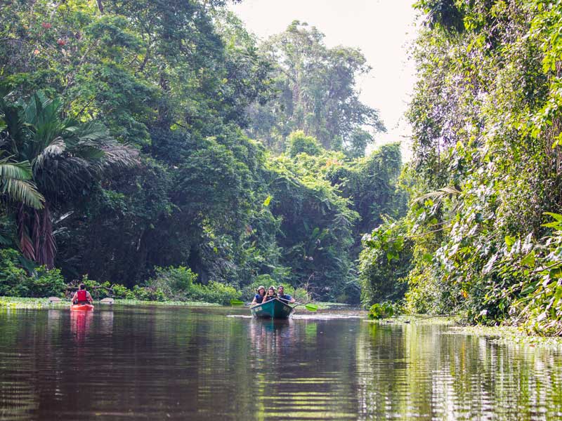 Um grupo de pessoas em cima de um barco num rio.