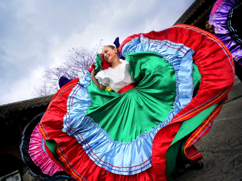 Uma mulher com um vestido colorido a dançar.