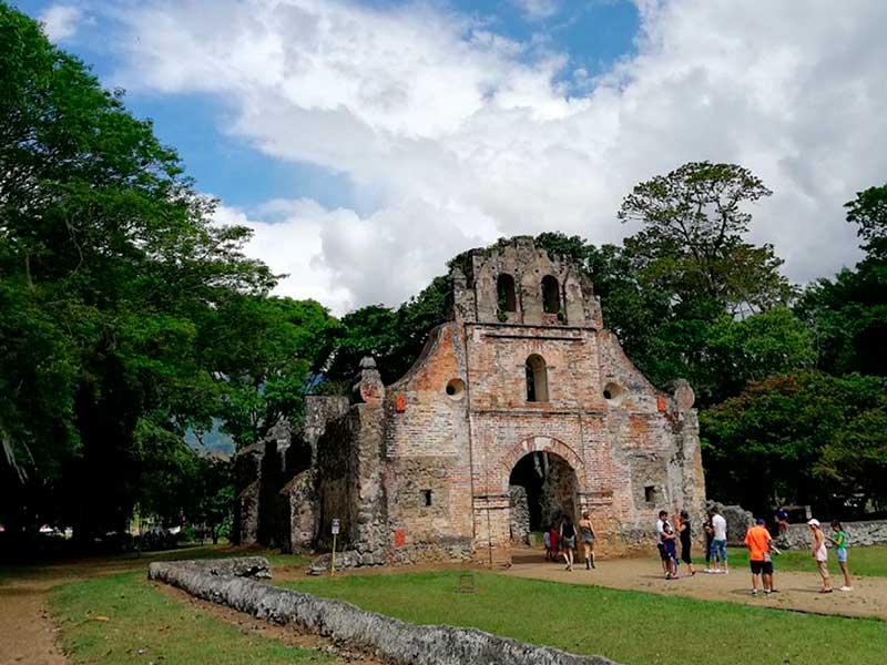 Um grupo de pessoas em frente a um edifício de pedra.