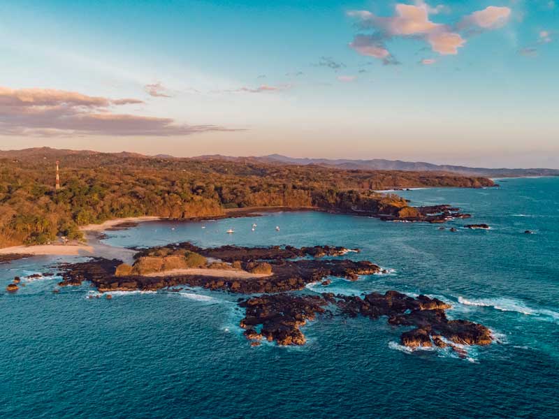 Vista aérea de uma ilha tropical com uma praia de areia.