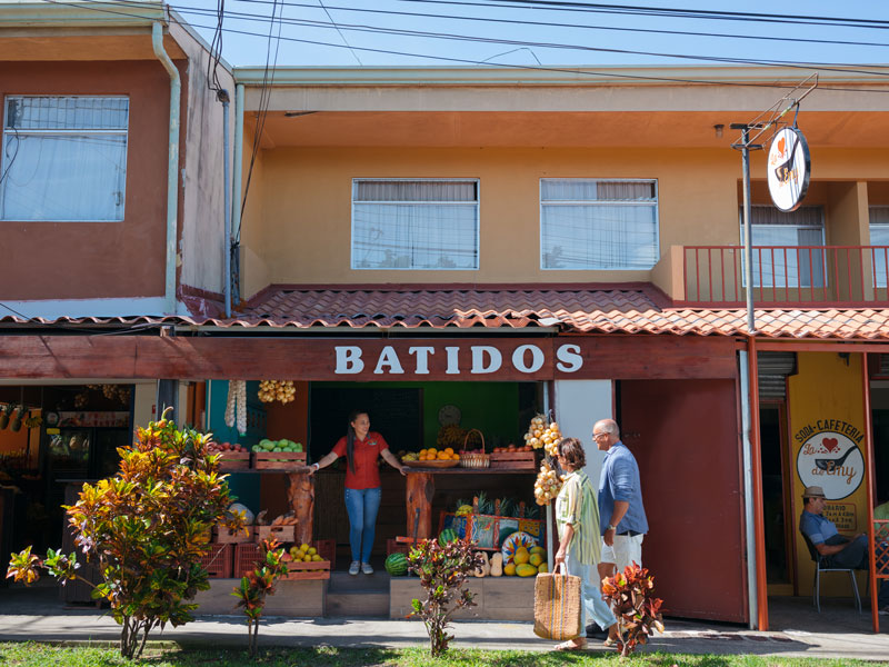 Um par de pessoas que estão em frente a uma loja.