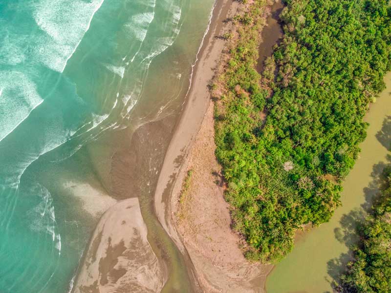 Uma vista aérea de uma praia e de uma massa de água.
