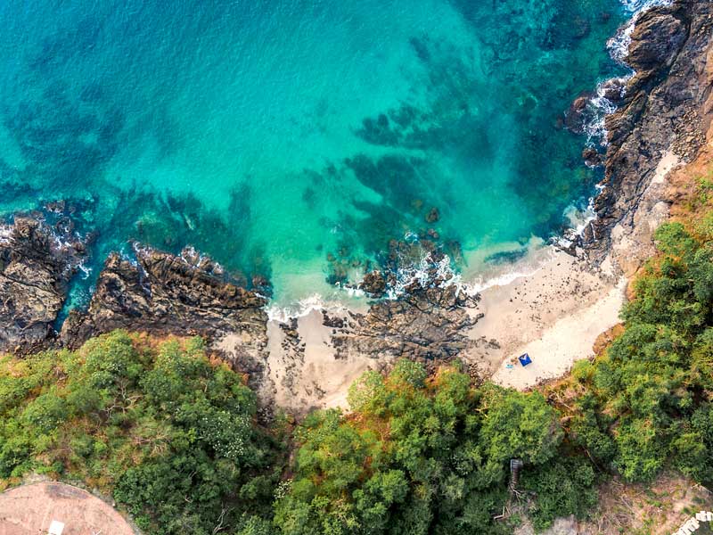 Uma vista aérea de uma praia e de uma massa de água.