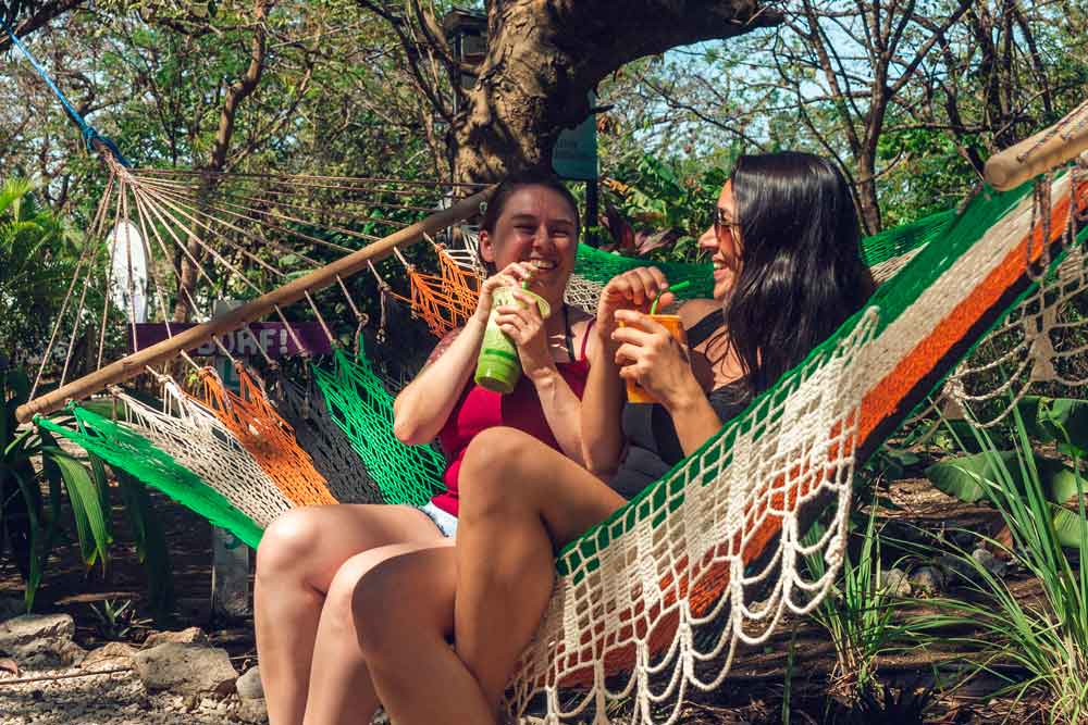Um casal de mulheres sentadas numa rede.