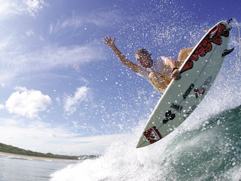 Um homem a apanhar uma onda em cima de uma prancha de surf.