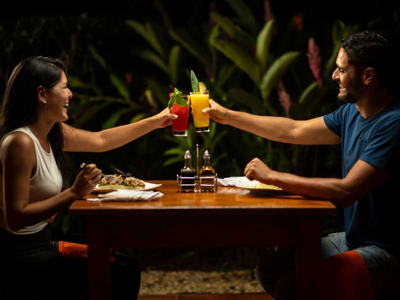 Um homem e uma mulher sentados numa mesa com bebidas.