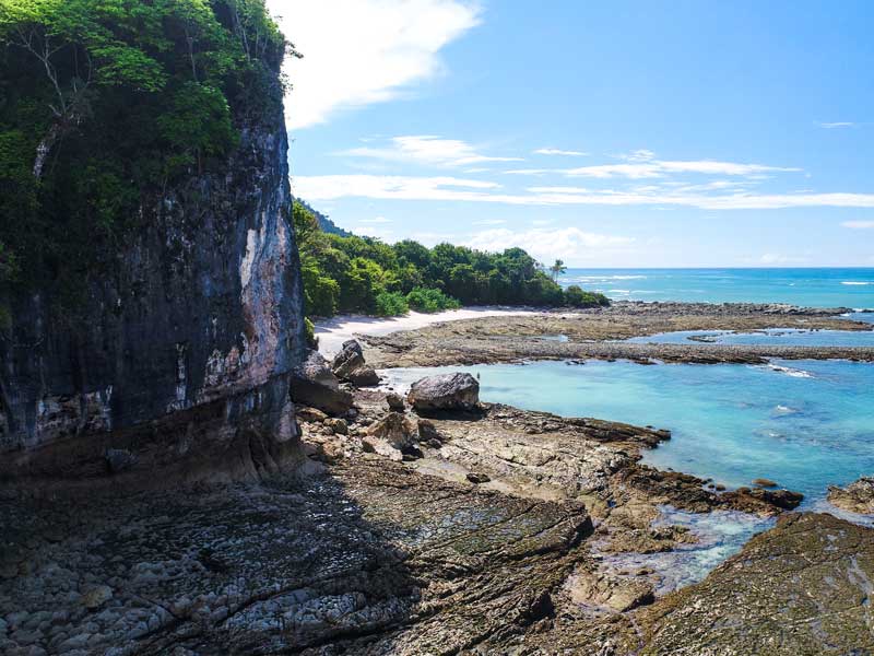 Vista de uma praia rochosa com água azul clara