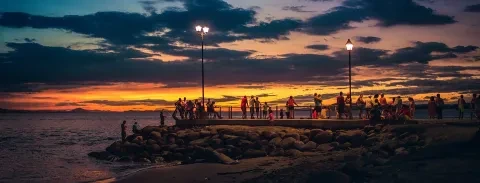Pessoas a apreciar simplesmente o pôr-do-sol na praia