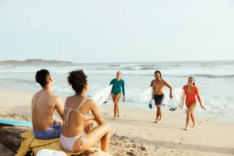 amigos a sair da água depois de surfarem na praia de Guiones