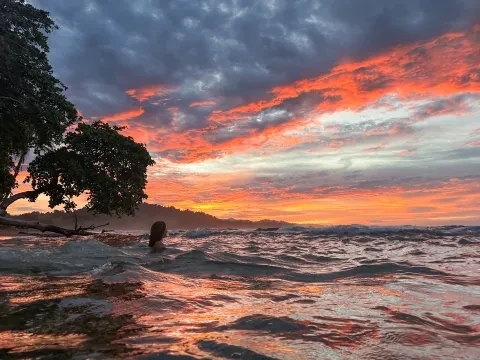 uma pessoa no oceano ao pôr-do-sol