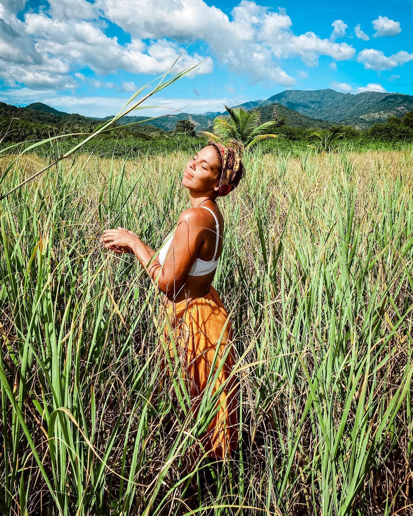 Uma mulher parada em um campo de grama alta