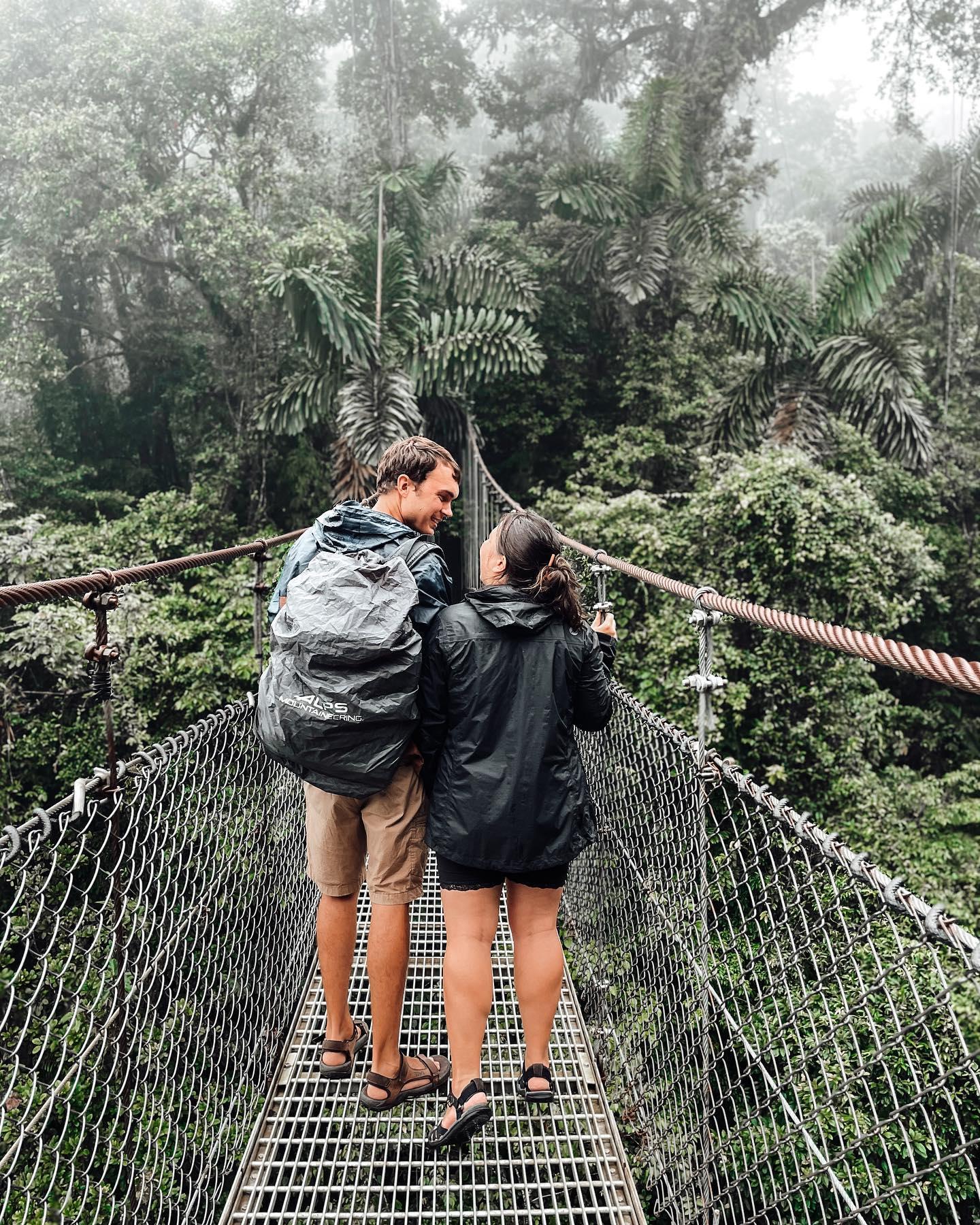 Um casal caminhando na ponte suspensa