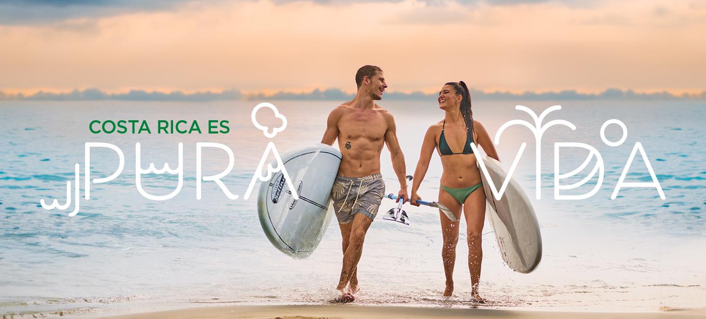 casal a caminhar na praia com pranchas de surf e textopura vida" à sua volta