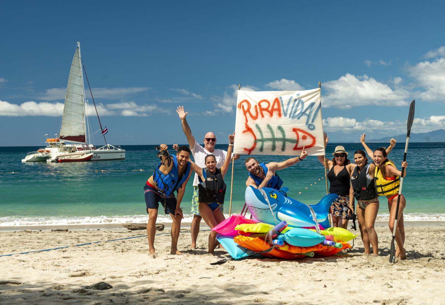 Pessoas na praia com um sinal de pura vida